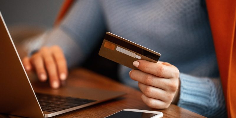 Unrecognizable woman using credit card and shopping online. Close up.